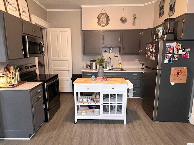 kitchen featuring sink, gray cabinetry, dark hardwood / wood-style flooring, stainless steel appliances, and crown molding