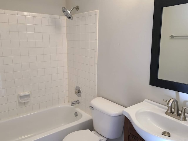 full bathroom featuring tiled shower / bath, vanity, and toilet