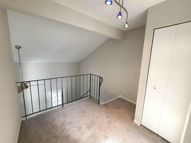 additional living space featuring carpet flooring and lofted ceiling with beams