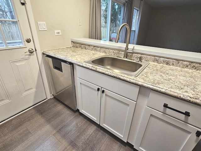 kitchen with dishwasher, sink, dark hardwood / wood-style flooring, plenty of natural light, and white cabinets