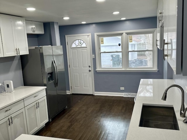 kitchen featuring stainless steel fridge with ice dispenser, dark wood-type flooring, white cabinetry, and sink