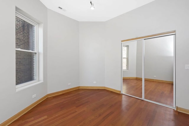 unfurnished bedroom with hardwood / wood-style flooring and a closet