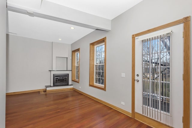 unfurnished living room with a healthy amount of sunlight and wood-type flooring