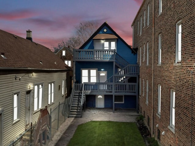 back house at dusk featuring a balcony