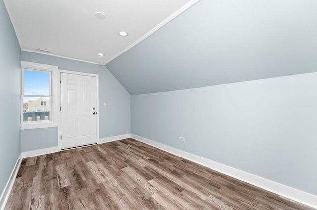 additional living space with hardwood / wood-style floors and lofted ceiling