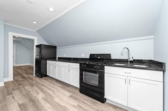 kitchen with sink, light hardwood / wood-style floors, vaulted ceiling, white cabinets, and black appliances