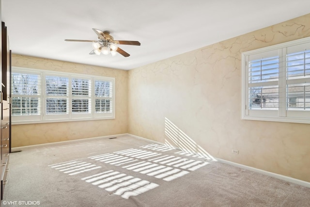 carpeted empty room featuring ceiling fan and a wealth of natural light