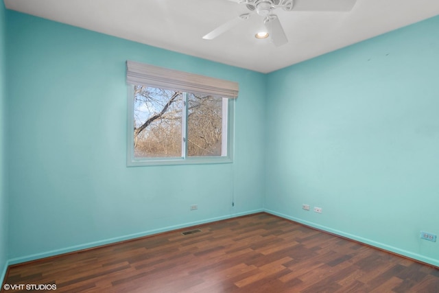 empty room with dark wood-type flooring and ceiling fan