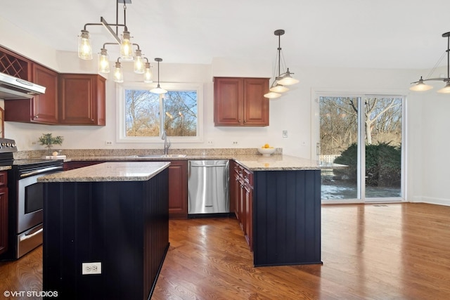 kitchen with decorative light fixtures, sink, and stainless steel appliances