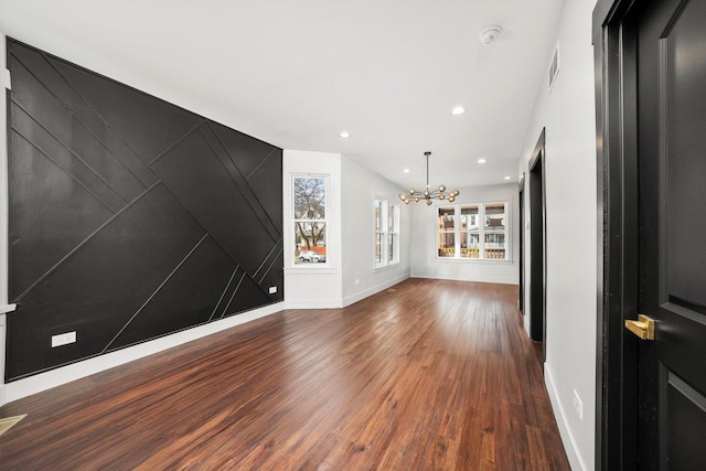 spare room with a notable chandelier, recessed lighting, visible vents, wood finished floors, and baseboards