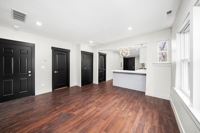 interior space with baseboards, visible vents, and dark wood-type flooring