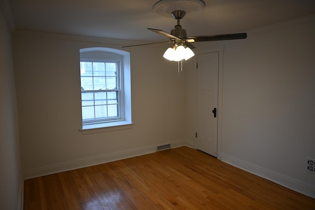 spare room with hardwood / wood-style floors, ornamental molding, and ceiling fan