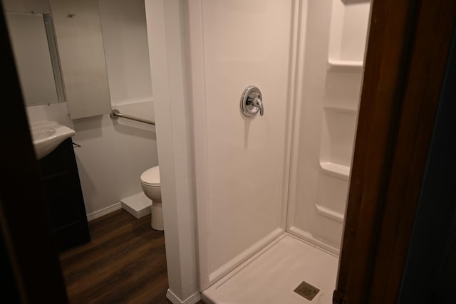 bathroom with vanity, hardwood / wood-style flooring, a shower, and toilet