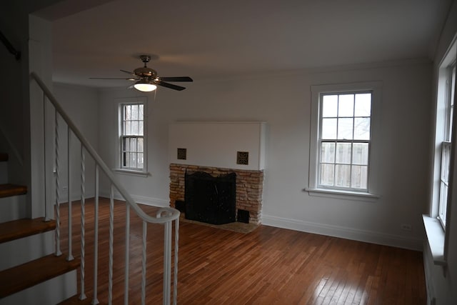 living room with hardwood / wood-style flooring, ceiling fan, a fireplace, and crown molding