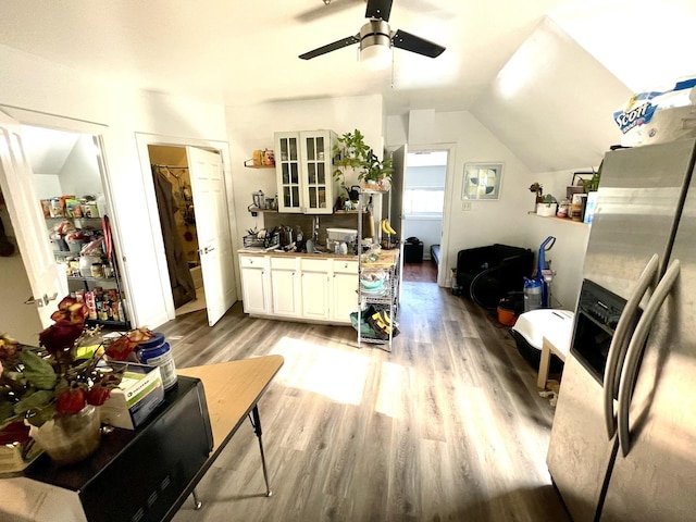 interior space featuring ceiling fan, light wood-type flooring, and lofted ceiling