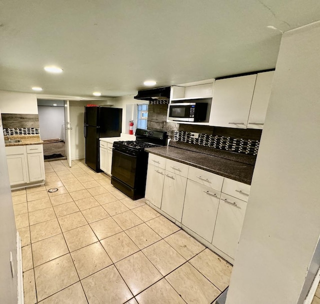 kitchen with tasteful backsplash, white cabinets, black appliances, and light tile patterned floors