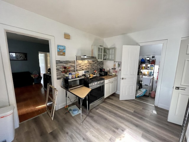 kitchen with backsplash, stainless steel appliances, white cabinetry, and dark wood-type flooring