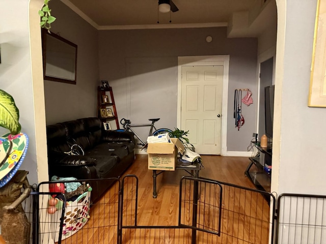 interior space featuring hardwood / wood-style flooring, ceiling fan, and crown molding