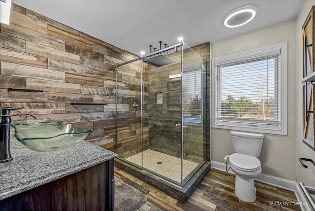 bathroom featuring vanity, toilet, an enclosed shower, and wood walls