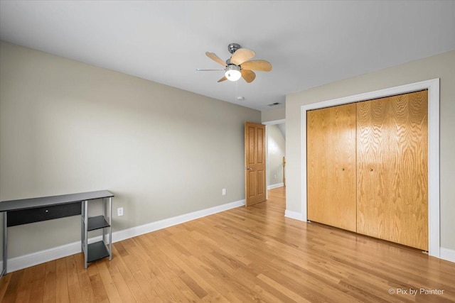 unfurnished bedroom featuring light hardwood / wood-style floors, a closet, and ceiling fan