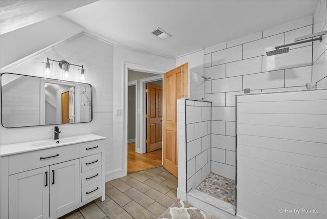 bathroom with vanity and tiled shower