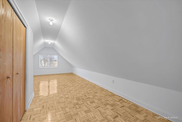 bonus room with lofted ceiling and light parquet flooring