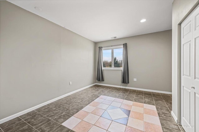 interior space featuring dark tile patterned floors and a closet