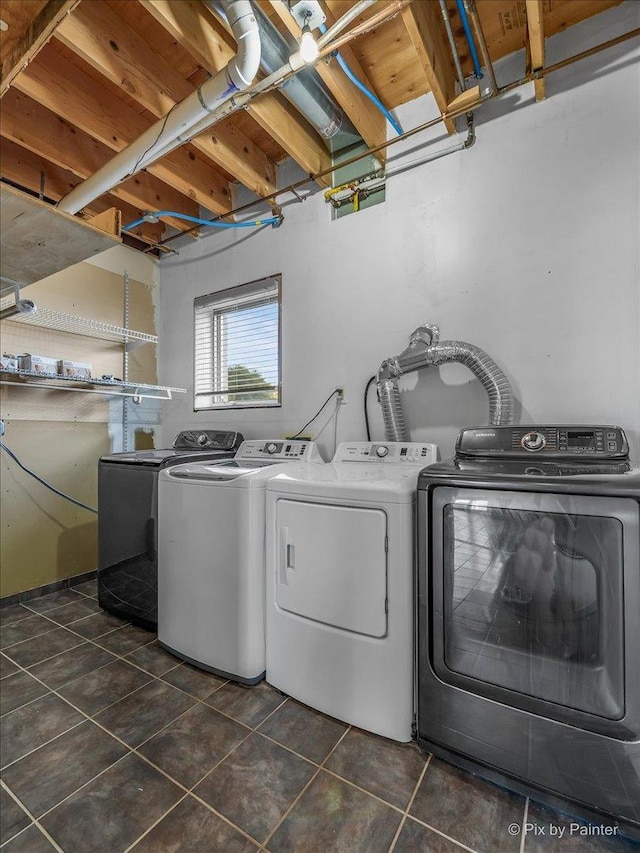 laundry room with washing machine and dryer and dark tile patterned floors