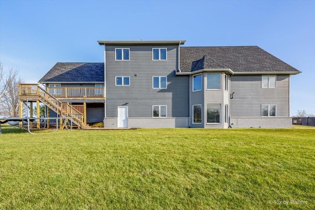 rear view of house featuring a lawn and a wooden deck