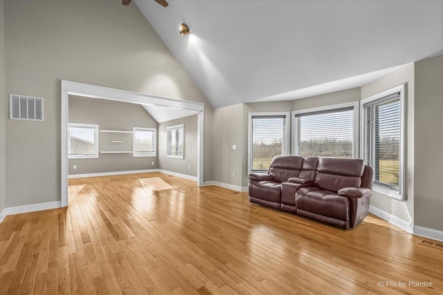 living room with light wood-type flooring, ceiling fan, and lofted ceiling