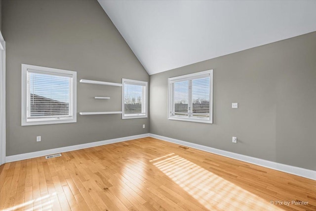 empty room featuring hardwood / wood-style floors and high vaulted ceiling