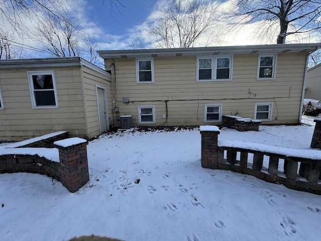 snow covered rear of property with cooling unit