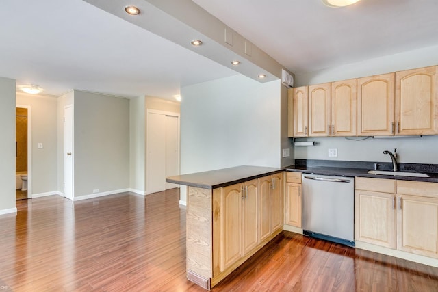 kitchen with sink, light brown cabinets, dark hardwood / wood-style flooring, stainless steel dishwasher, and kitchen peninsula