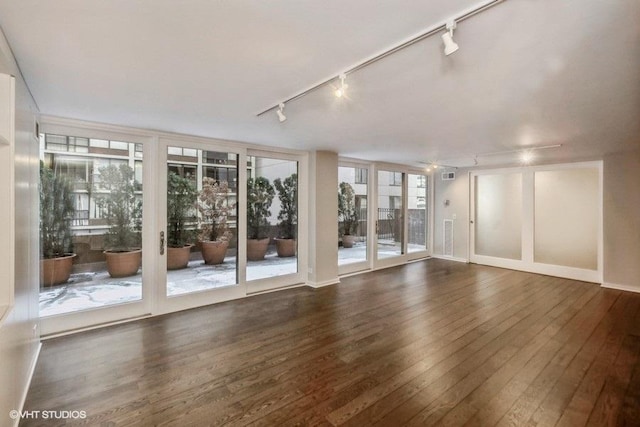 unfurnished room with rail lighting and dark hardwood / wood-style floors