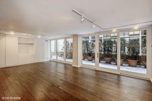 interior space featuring dark hardwood / wood-style floors and rail lighting