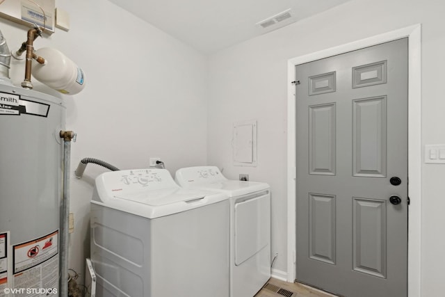 washroom with washer and dryer and gas water heater