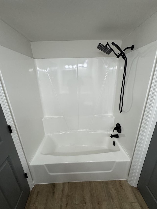 bathroom with hardwood / wood-style flooring and shower / washtub combination