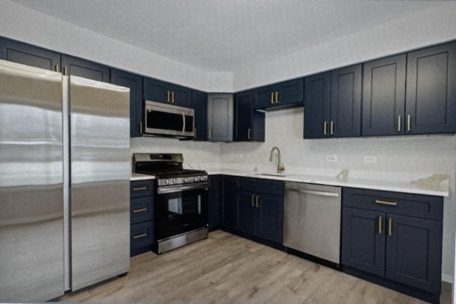 kitchen with light wood-type flooring, stainless steel appliances, and sink