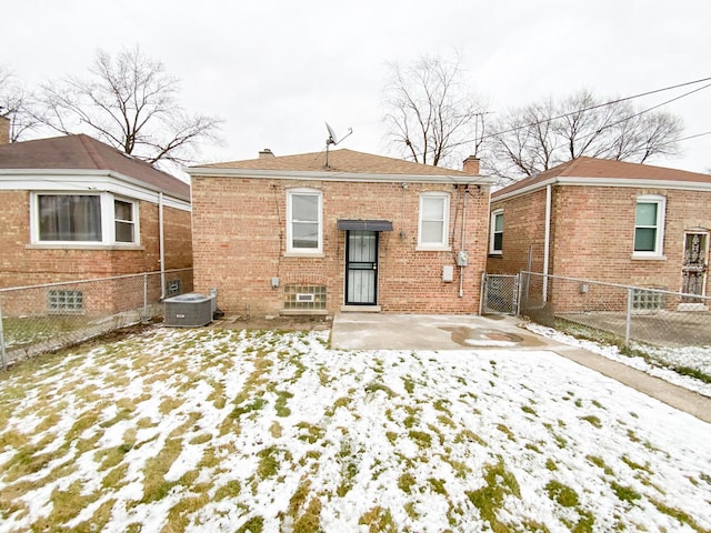 snow covered back of property with central AC unit