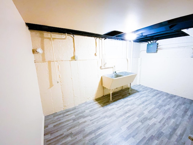 basement featuring wood-type flooring and sink