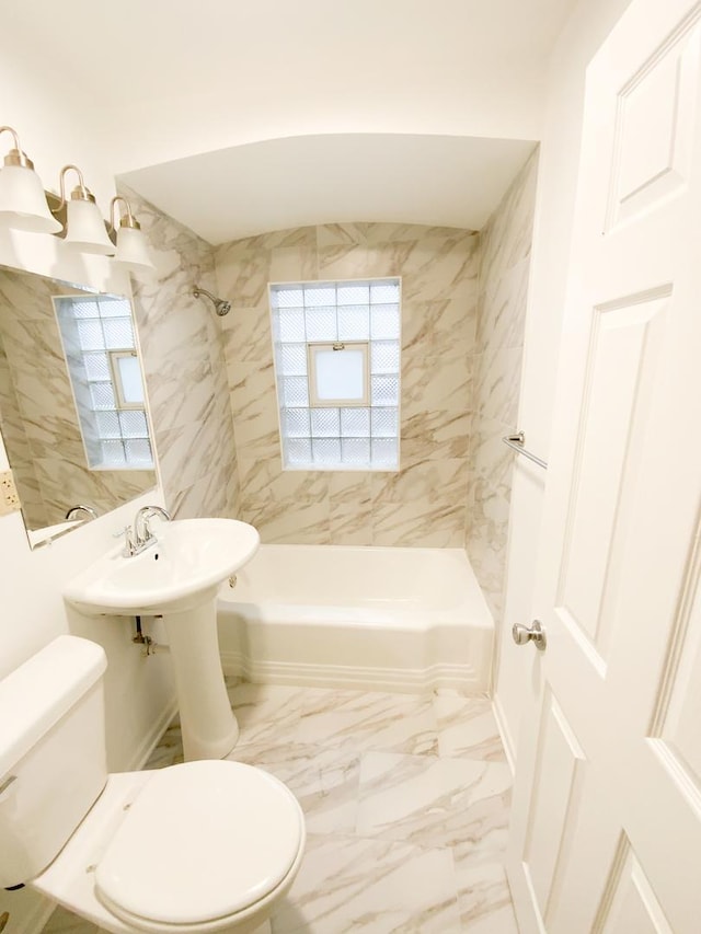 bathroom with toilet and tiled shower / bath