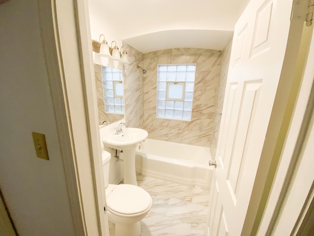 bathroom with tiled shower / bath combo and toilet