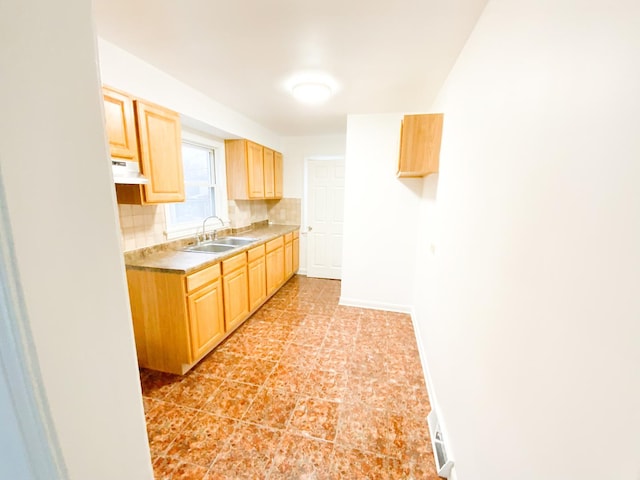 kitchen with backsplash, light brown cabinets, and sink