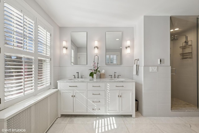 bathroom with tile walls, a sink, a shower stall, and radiator heating unit