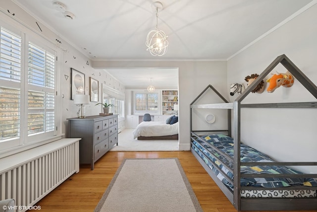 bedroom featuring radiator, ornamental molding, and wood finished floors