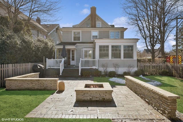 back of house with fence private yard, a fire pit, a lawn, and a patio