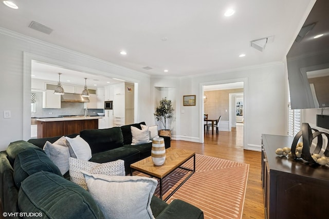 living room with recessed lighting, visible vents, ornamental molding, wood finished floors, and baseboards