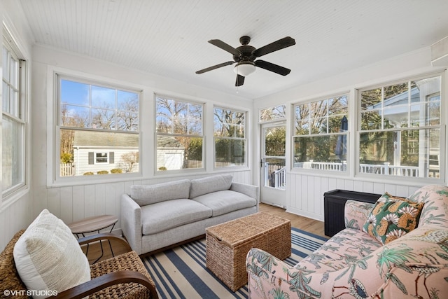 sunroom / solarium with wood ceiling, a ceiling fan, and a wealth of natural light