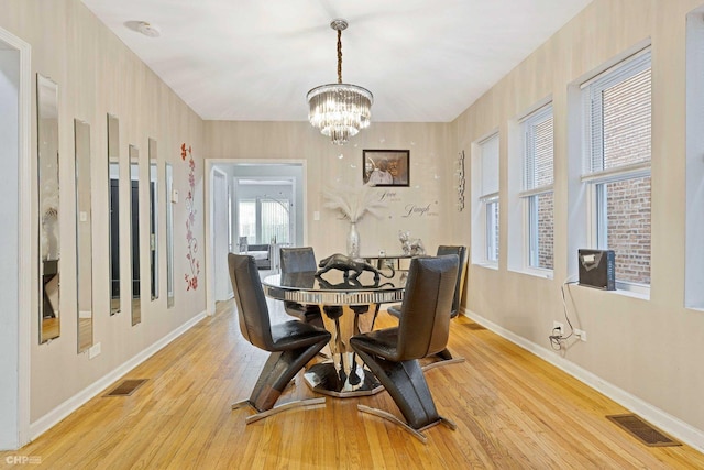 dining space featuring light hardwood / wood-style flooring and an inviting chandelier