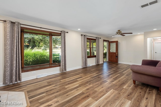 living room with wood-type flooring, plenty of natural light, and ceiling fan